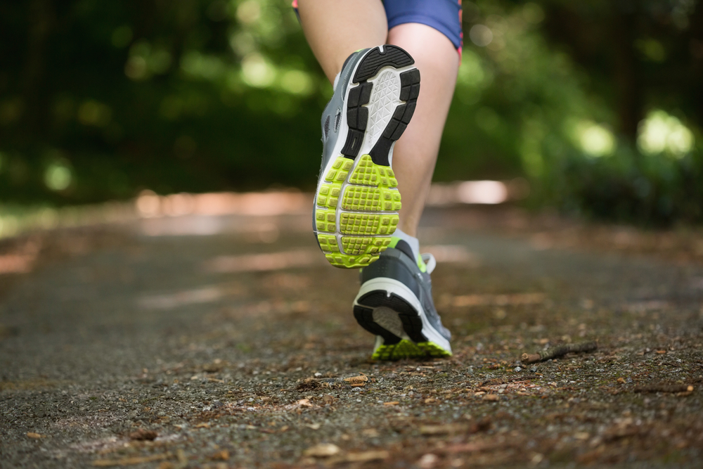 Woman jogging away from camera wearing trainers